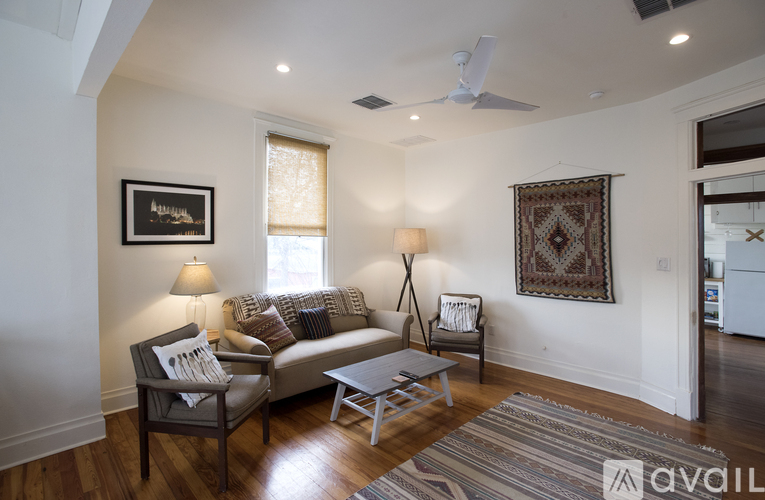 A living room with a couch, chair, and rug.