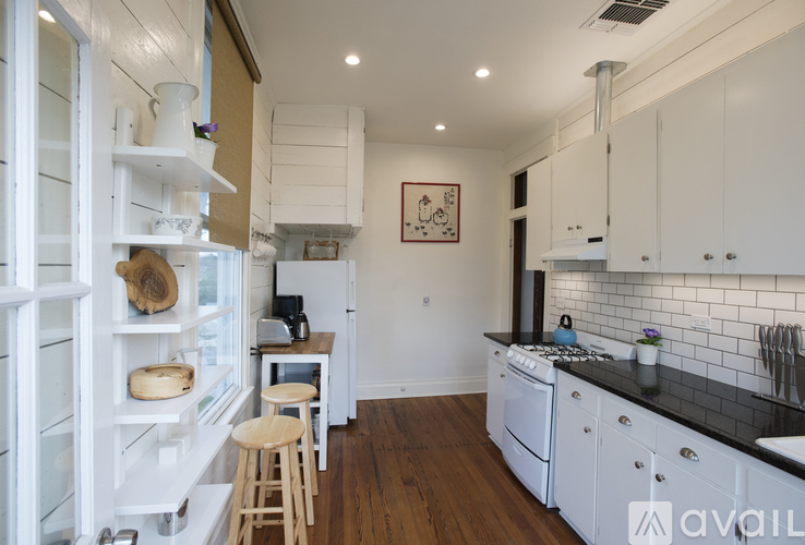 A kitchen with white cabinets and a black countertop.