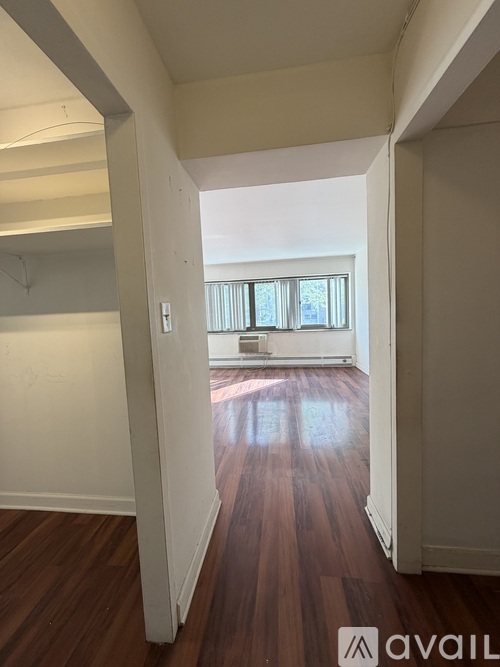 A hallway with wood floors and white walls.