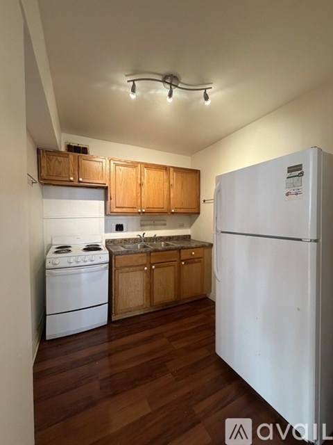 A kitchen with wooden cabinets and a white fridge.