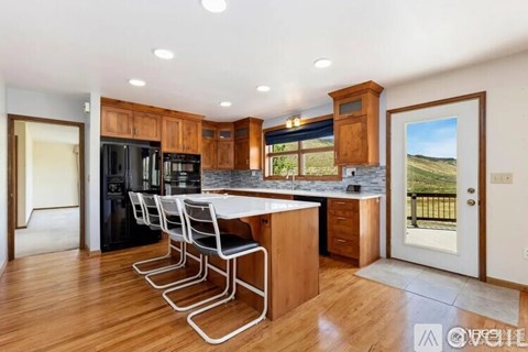 A kitchen with a black fridge and white countertops.