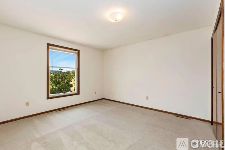 Empty room with a window and a view of trees outside.