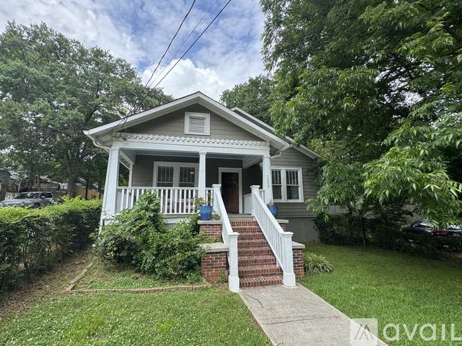 A small house with a front porch and a brick staircase leading to the door.