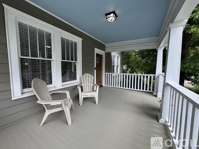 A porch with two chairs and a table.