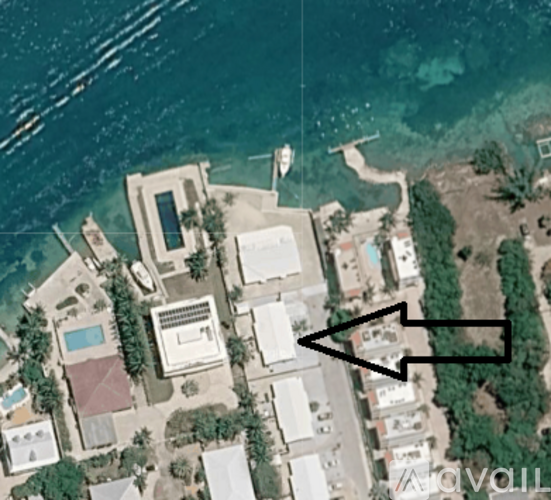 A bird's eye view of a residential area with a large house and a swimming pool.