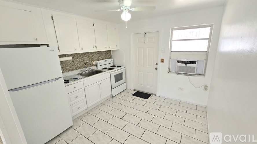 A kitchen with white appliances and cabinets.