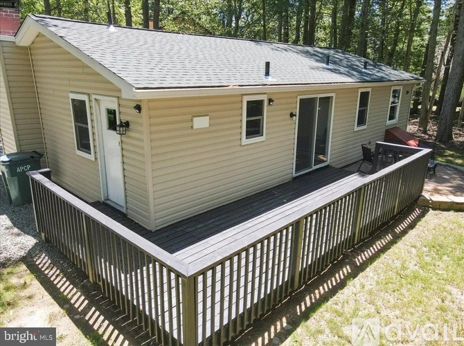 A small house with a deck in the woods.