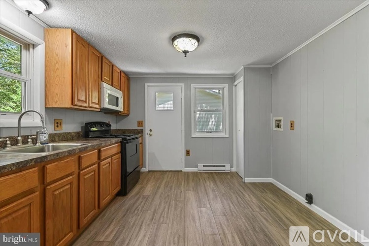 A kitchen with wooden cabinets and a black stove top oven.