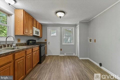 A kitchen with wooden cabinets and a black stove top oven.