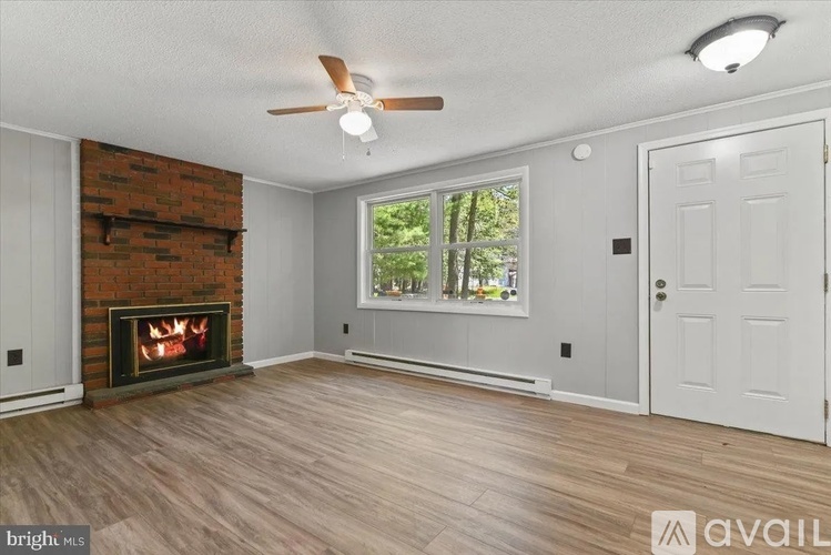 A room with a fireplace and a ceiling fan.
