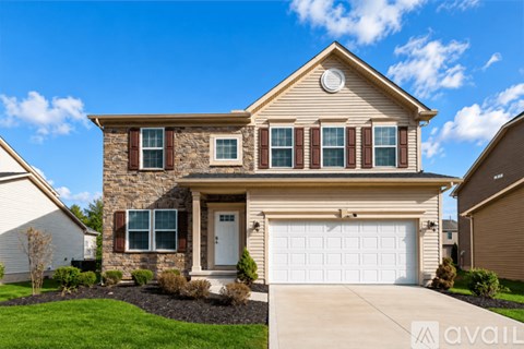 A house with a garage door and a driveway in front.