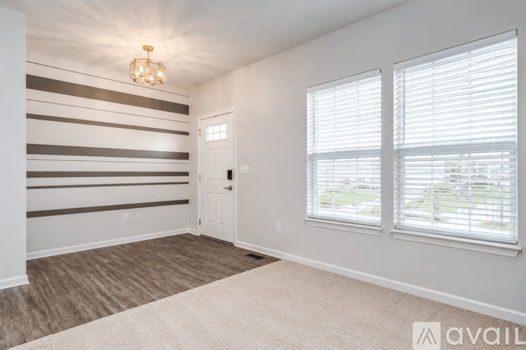 A room with a striped wallpaper on the wall and a carpet on the floor.