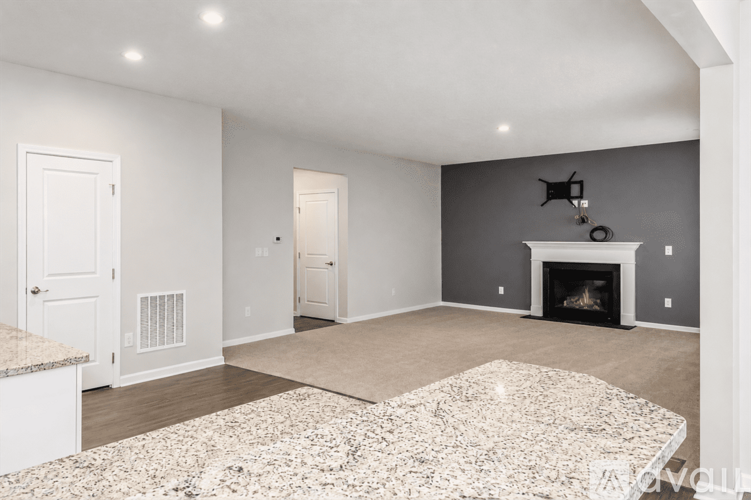 A living room with a fireplace and a rug on the floor.