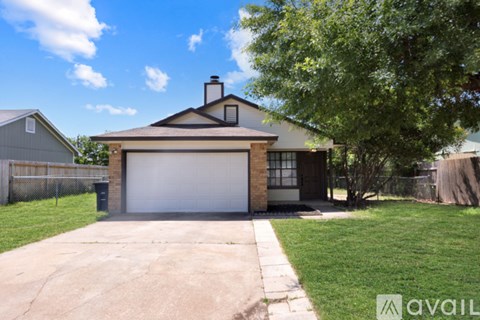 A house with a garage and a driveway in front of it.