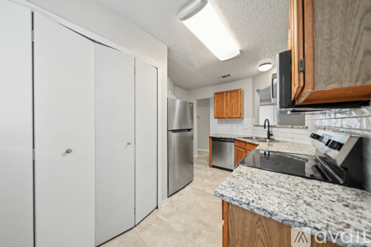 A kitchen with a granite counter top and white cabinets.