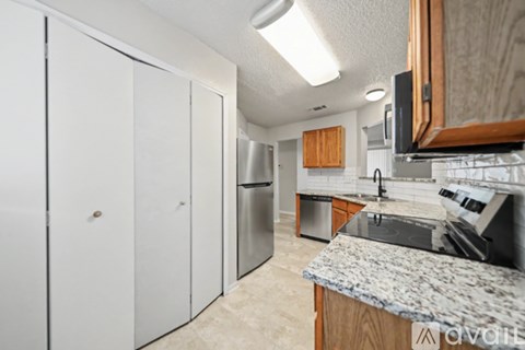A kitchen with a granite counter top and white cabinets.