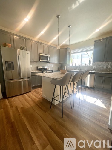 A kitchen with wooden floors and a white island.
