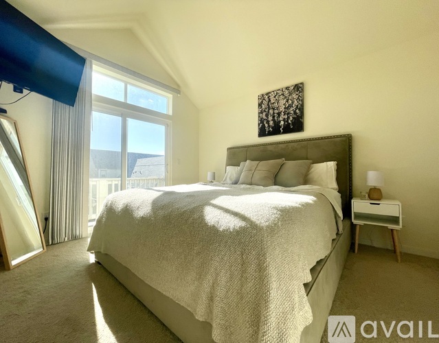 A bedroom with a large bed and a window overlooking the city.
