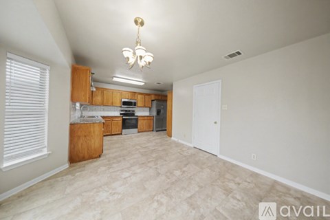 A kitchen area with wooden cabinets and a microwave.