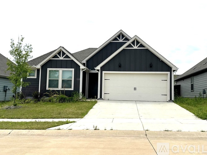 A black house with a white garage door.