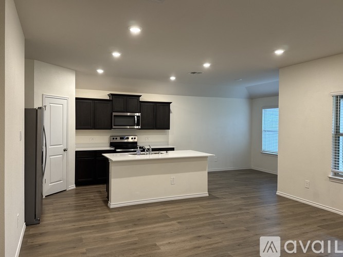 A modern kitchen with white cabinets and a white island.