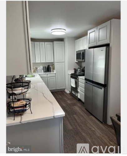 A kitchen with white cabinets and a white countertop.