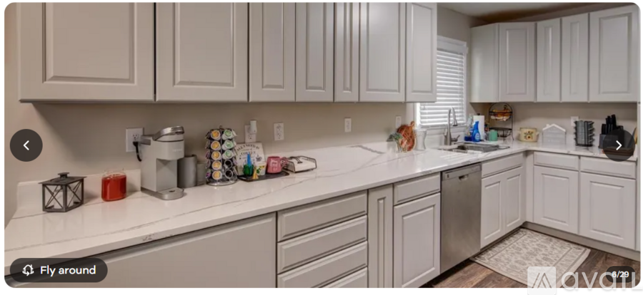 A kitchen with white cabinets and a white countertop.