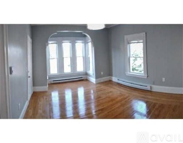 A room with wooden floors and a large window.