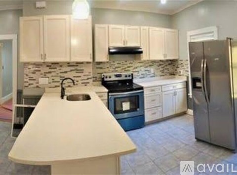 A kitchen with a white countertop and a stainless steel refrigerator.