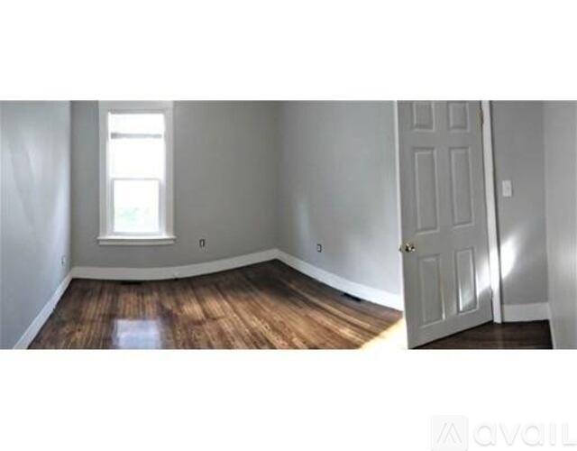 A room with a wooden floor and a white door.