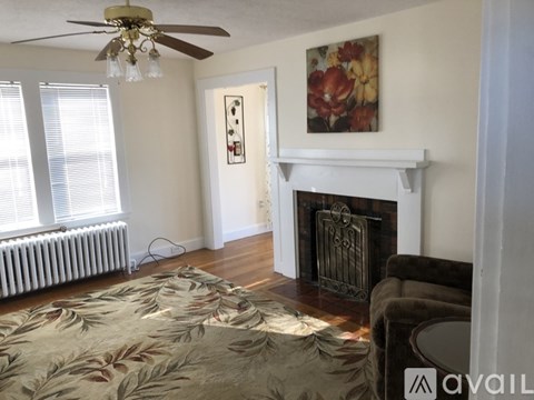 A living room with a fireplace and a painting on the wall.