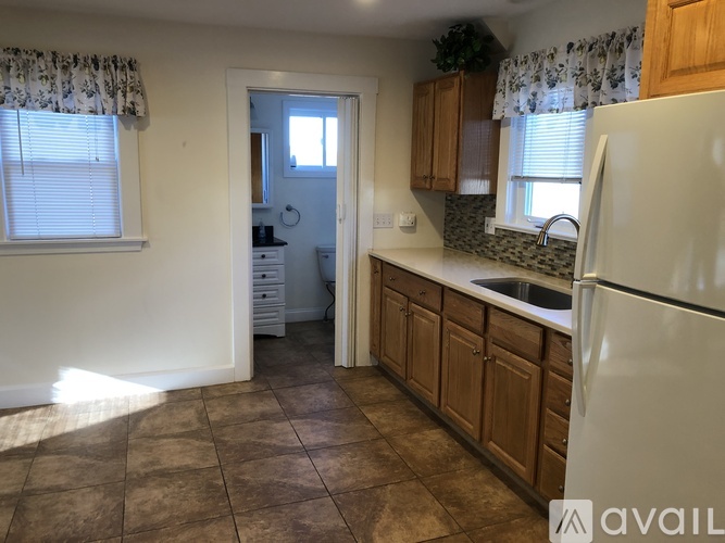 A kitchen with brown cabinets and a white fridge.