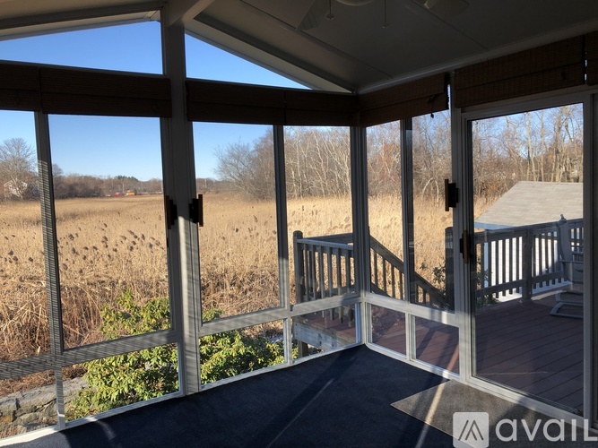 A balcony with a view of a field and trees.