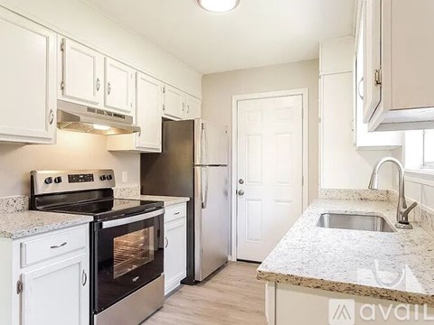 A kitchen with white cabinets and granite countertops.