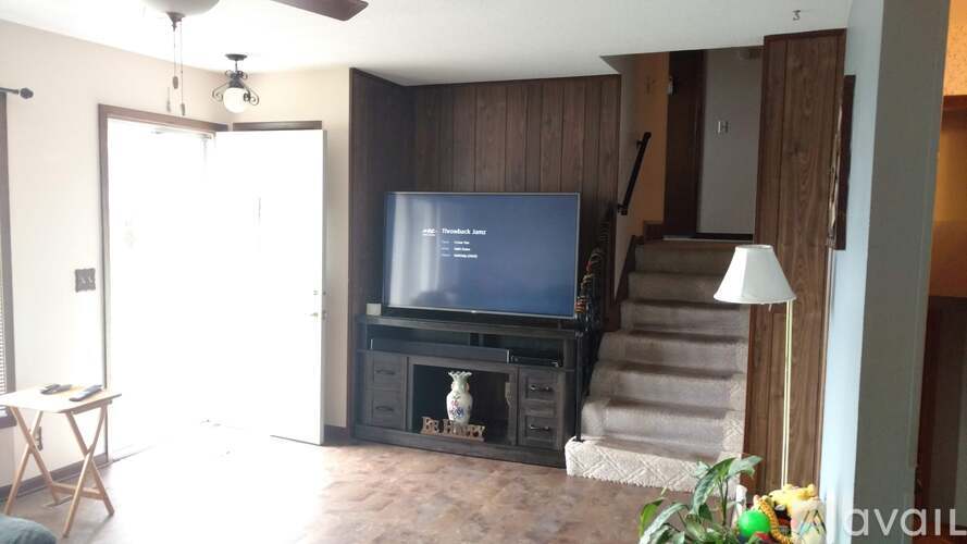 A living room with a television and a chair.