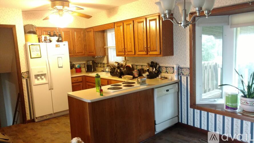 A kitchen with wooden cabinets and a white refrigerator.