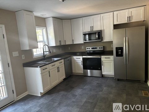 A kitchen with white cabinets and stainless steel appliances.
