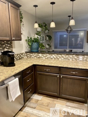 A kitchen with brown cabinets and a granite countertop.