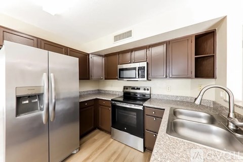 A kitchen with a stainless steel refrigerator, microwave, and dishwasher.