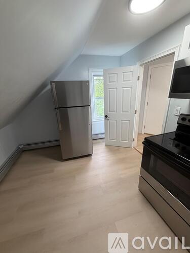 A kitchen with a stainless steel refrigerator and a black oven.