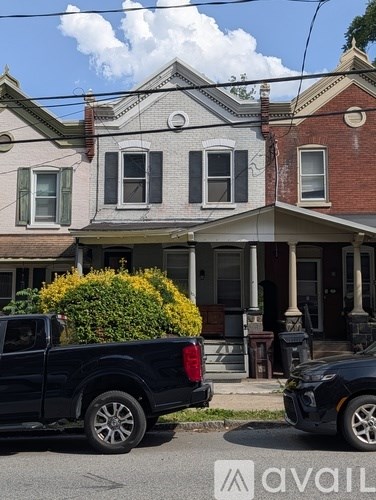 A black truck is parked in front of a house.