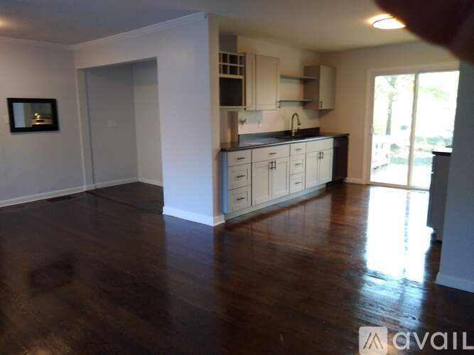 A kitchen with white cabinets and a dark floor.