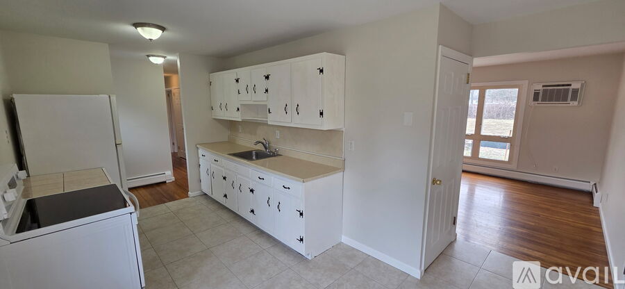 A kitchen with white cabinets and appliances is available for rent.