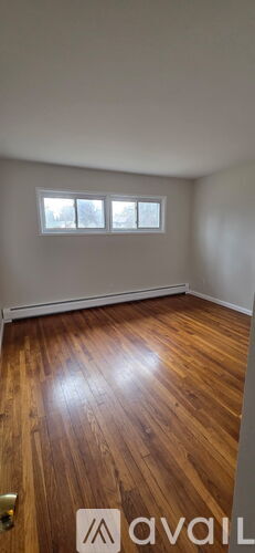 A room with wooden flooring and a window.