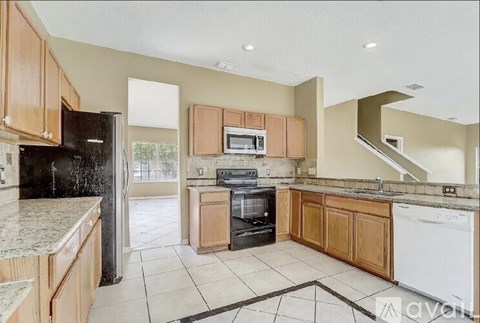 A kitchen with wooden cabinets and black appliances.