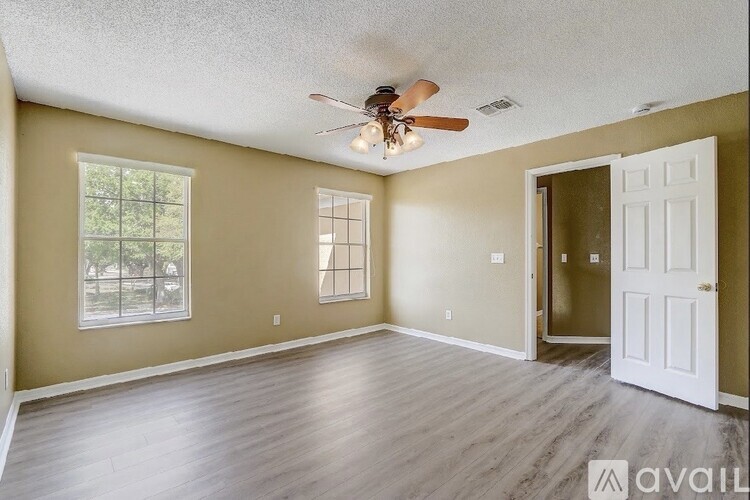 A room with a ceiling fan and a door.