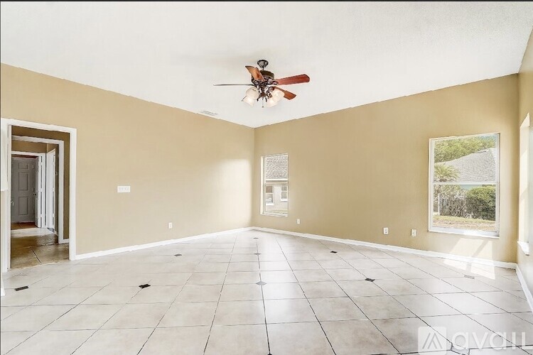 A spacious room with a ceiling fan and tiled flooring.