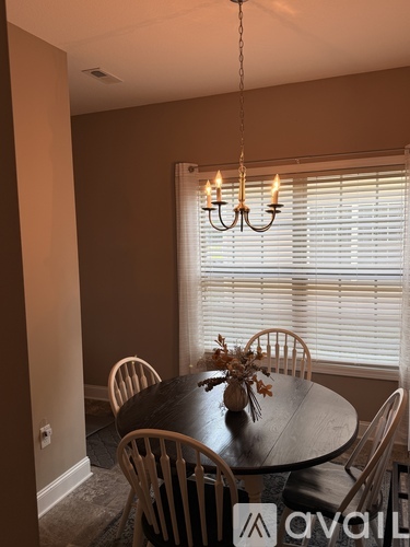 A dining room with a round table and chairs.