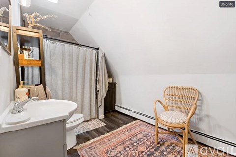 A white sink in a bathroom with a wooden chair.