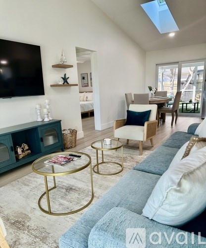 A living room with a blue couch and a glass table.